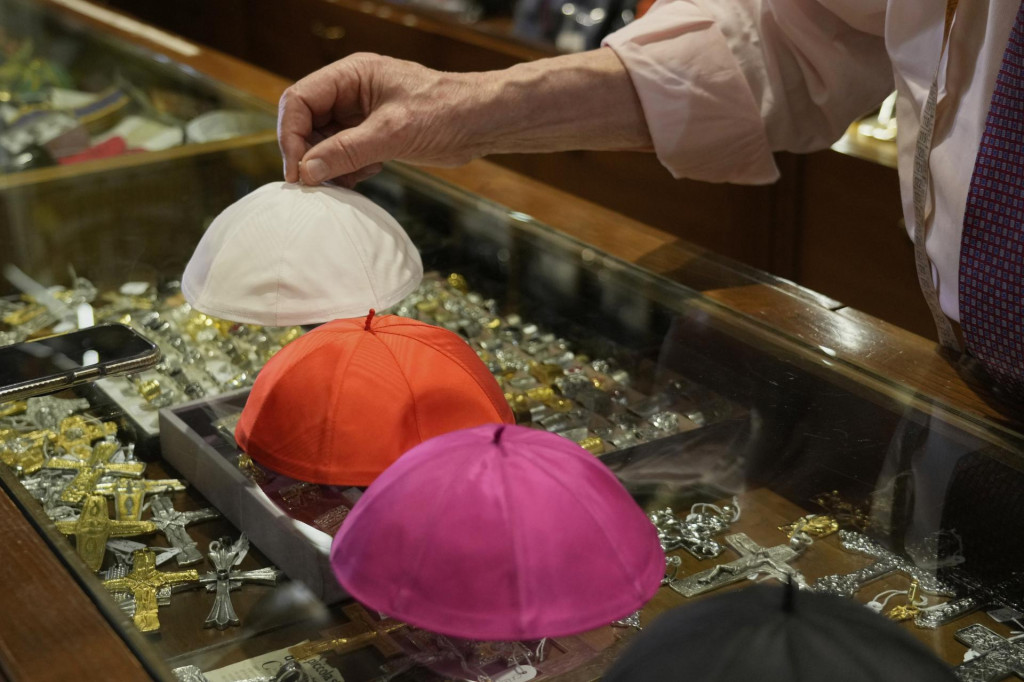 87-ročný taliansky krajčír Raniero Mancinelli (zobrazené ruky), ktorý z vlastnej iniciatívy šije oblečenie pre budúceho pápeža, ukazuje solideo vo svojom obchode v Ríme. FOTO: TASR/AP