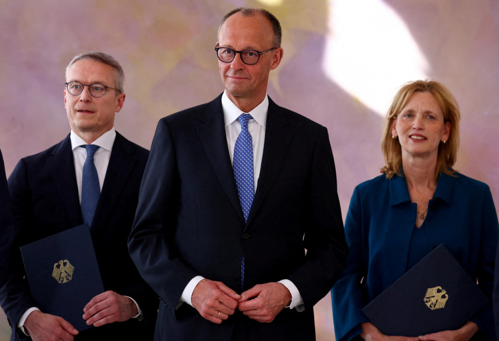 Nemecký kancelár Friedrich Merz sleduje, ako nominovaná nemecká ministerka pre rodinu Karin Prien a nominovaný nemecký minister pre digitalizáciu a modernizáciu štátu Karsten Wildberger držia svoje vymenovacie certifikáty počas slávnostného ceremoniálu v paláci Bellevue v Berlíne. FOTO: Reuters