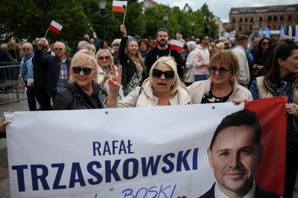 Účastníčky volebného zhromaždenia konaného 11. mája v stredopoľskom Plocku držia transparent na podporu favorizovaného prezidentského kandidáta Rafala Trzaskowského. FOTO: Reuters