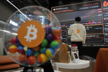 Zamestnanec sleduje elektronickú obrazovku, ktorá zobrazuje obchodovanie na burze s kryptomenou bitcoin v Soule. FOTO: TASR/AP