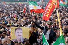 Osoba drží vlajku s vyobrazením uväzneného kurdského militantného vodcu Abdullaha Öcalana. FOTO: Reuters