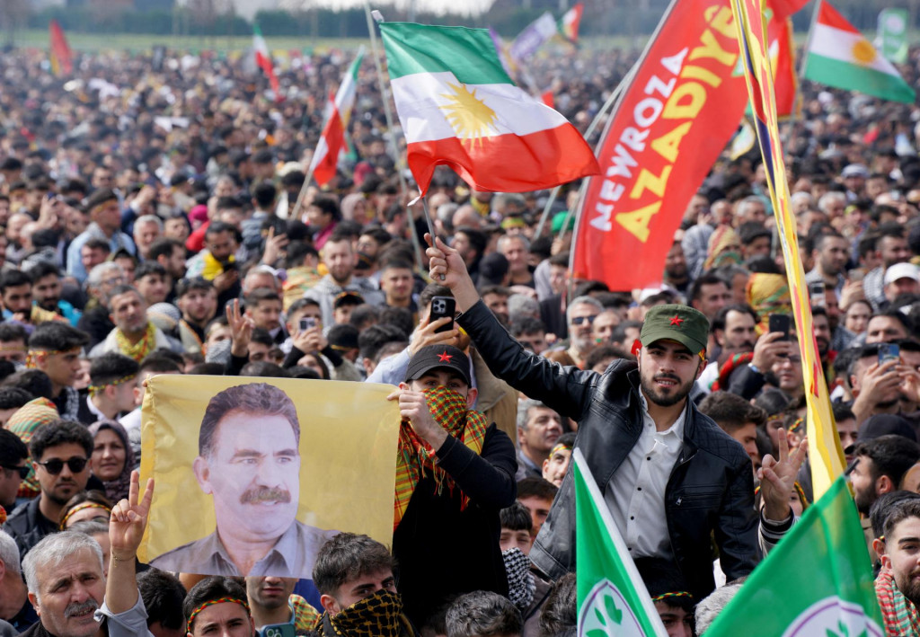 Osoba drží vlajku s vyobrazením uväzneného kurdského militantného vodcu Abdullaha Öcalana. FOTO: Reuters