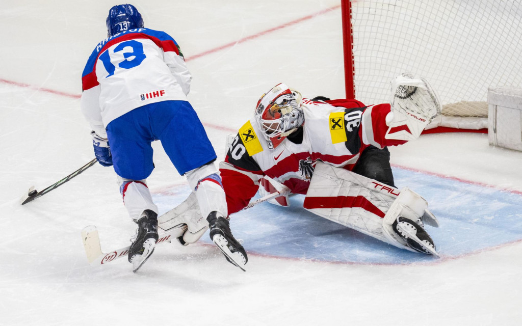 Na snímke vľavo Michal Krištof (Slovensko) proti rakúskemu brankárovi Davidovi Kickertovi (vpravo) v nájazde po predĺžení zápasu základnej A-skupiny Rakúsko - Slovensko na 88. majstrovstvách sveta v ľadovom hokeji vo švédskom Štokholme. FOTO: TASR/Jakub Kotian