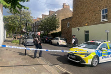 Osoba kráča k policajtovi na uzavretej ulici, kde v pondelok v skorých ranných hodinách vypukol požiar v dome britského premiéra Keira Starmera v severnom Londýne. FOTO: Reuters