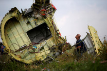 Malajzijský vyšetrovateľ leteckých nehôd kontroluje miesto havárie letu MH17. FOTO: Reuters