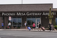 Cestujúci kráčajú pred letiskom Mesa Gateway, kde letecká spoločnosť Avelo Airlines začala v pondelok v mene federálnej vlády vykonávať deportačné lety v meste Mesa v americkom štáte Arizona. FOTO: TASR/AP