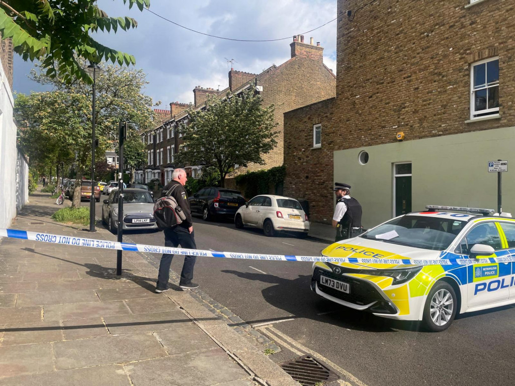 Osoba kráča k policajtovi na uzavretej ulici, kde v pondelok v skorých ranných hodinách vypukol požiar v dome britského premiéra Keira Starmera v severnom Londýne. FOTO: Reuters