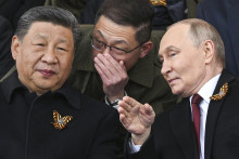 Na snímke vpravo ruský prezident Vladimir Putin a čínsky prezident Si Ťin-pching sa rozprávajú počas sledovania vojenskej prehliadky pri príležitosti 80. výročia konca druhej svetovej vojny v Európe v Moskve. FOTO: TASR/AP