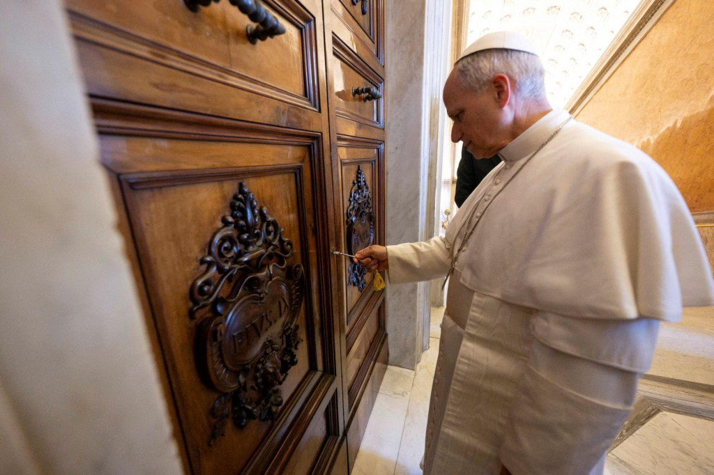Pápež Lev XIV. odomyká dvere do Apoštolského paláca po tom, ako boli odpečatené vo Vatikáne. FOTO: REUTERS
