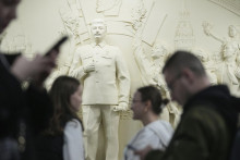Ľudia prechádzajú okolo zreštaurovaného basreliéfu „Vďačnosť ľudu vodcovi veliteľovi“ z roku 1960, ktorý zobrazuje sovietskeho vodcu Josifa Stalina na stanici metra Taganskaja pri príležitosti 90. výročia otvorenia metra v Moskve. FOTO: TASR/AP