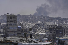 Palestínčania sa pozerajú ako dym stúpa pri explózii po izraelskom bombardovaní Pásma Gazy neďaleko mesta Džabalia, na severe Pásma Gazy. FOTO: TASR/AP