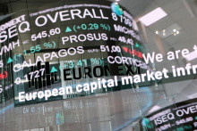 Odraz digitálnej tabule zobrazujúcej obchodné údaje na burze Euronext v obchodnej štvrti La Defense v Paríži. FOTO: Reuters