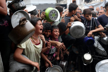 Deti reagujú, keď Palestínčania čakajú na jedlo pripravené charitatívnou kuchyňou v Beit Lahia v severnom pásme Gazy 24. apríla 2025. FOTO: REUTERS