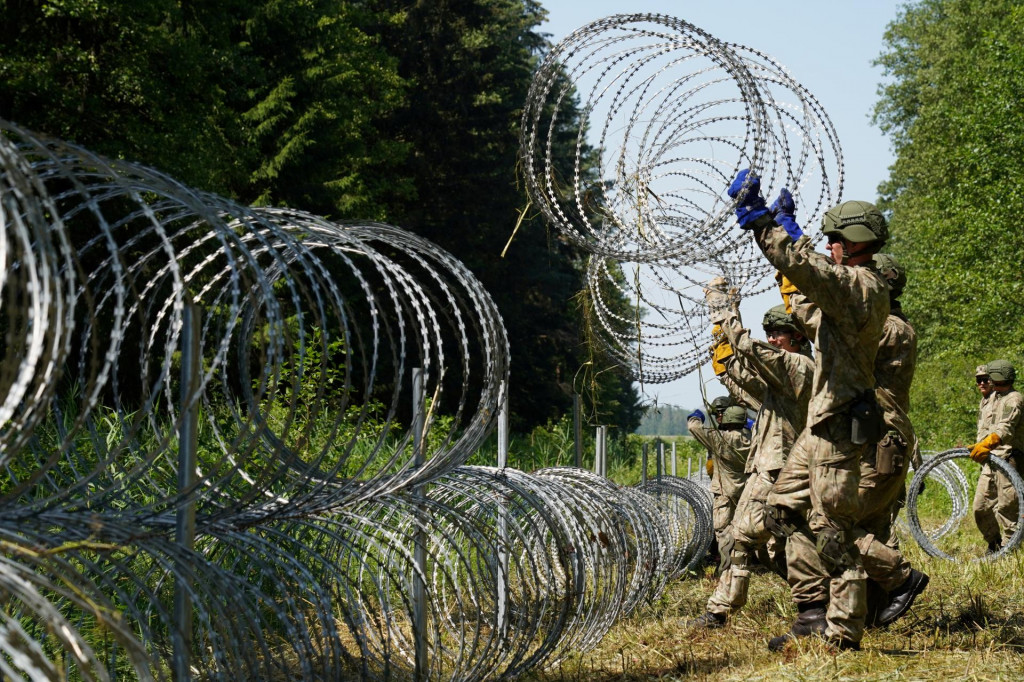 Litovskí vojaci inštalujú ostnatý drôt na hranici s Bieloruskom v Druskininkai v Litve 9. júla 2021. FOTO: REUTERS