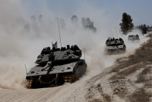 Vojenské vozidlá prechádzajú do Gazy. FOTO: Reuters