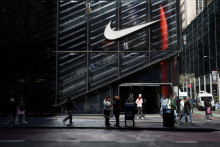 Ľudia prechádzajú okolo obchodu Nike v New Yorku v USA. FOTO: Reuters