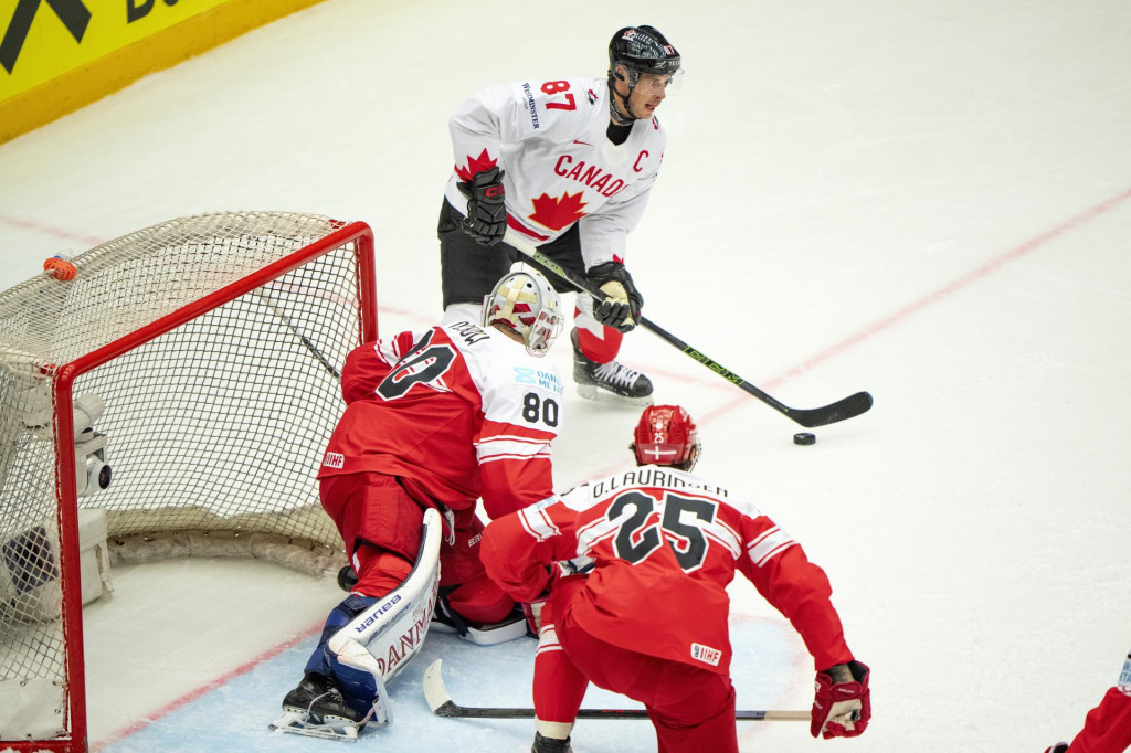 Kapitán Kanady Sidney Crosby (v pozadí), brankár Dánska Frederik Dichow (uprostred) a hokejista Dánska Oliver Lauridsen vo štvrťfinálovom zápase Dánsko - Kanada na 88. majstrovstvách sveta v ľadovom hokeji v Herningu. FOTO: TASR/AP