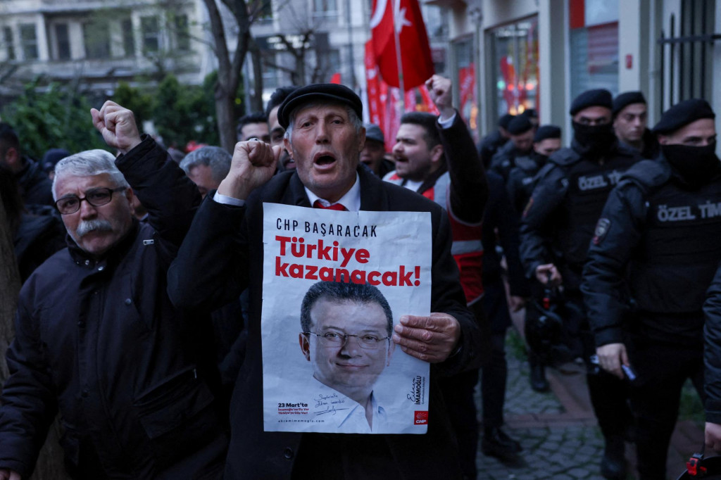 Muž drží plagát s fotografiou istanbulského starostu Ekrema Imamoglua počas protestu. FOTO: Reuters