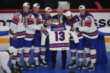 Americkí hráči držia trofej a dres zosnulého spoluhráča Johnnyho Gaudreaua po tom, ako získali titulu po ich víťazstve nad Švajčiarskom 1:0 po predĺžení. FOTO: TASR/AP