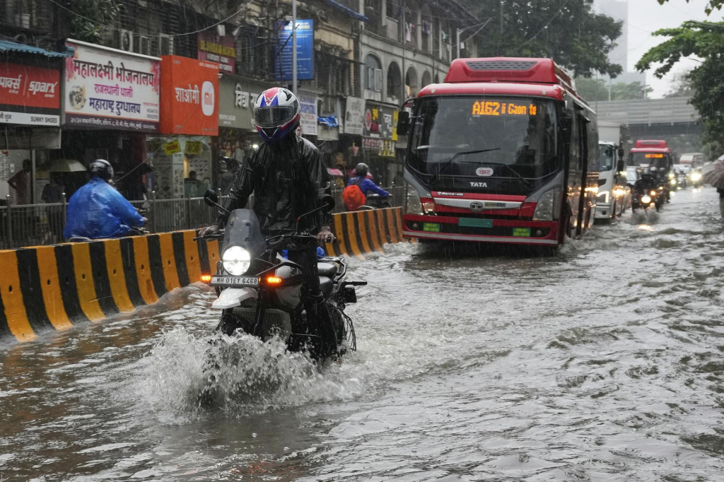Motocyklista jazdí po zaplavenej ceste počas silných dažďov v indickom Bombaji. FOTO: TASR/AP
