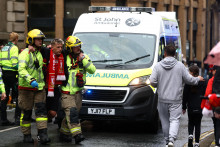 Záchranári odvádzajú fanúšika po incidente s autom a fanúšikmi počas prehliadky víťazstva. FOTO: Reuters