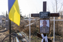 Portrét Serhija Hryhorjeva, ukrajinského vojnového zajatca, ktorý zomrel v Rusku, je viditeľný vedľa jeho hrobu v Pyrjatyne. FOTO: TASR/AP