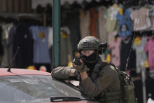 Izraelský vojak mieri zbraňou počas vojenskej razie. FOTO: TASR/AP