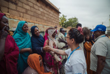 Člen Svetového potravinového programu si podáva ruku so ženou v Omdurmane v Sudáne. FOTO: Reuters
