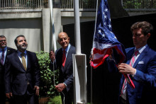 Sýrsky minister zahraničných vecí Asaad Hassan al-Šíbání stojí vedľa amerického vyslanca pre Sýriu Thomasa Barracka, keď vztýčuje americkú vlajku pred rezidenciou amerického veľvyslanca v Damasku. FOTO: Reuters