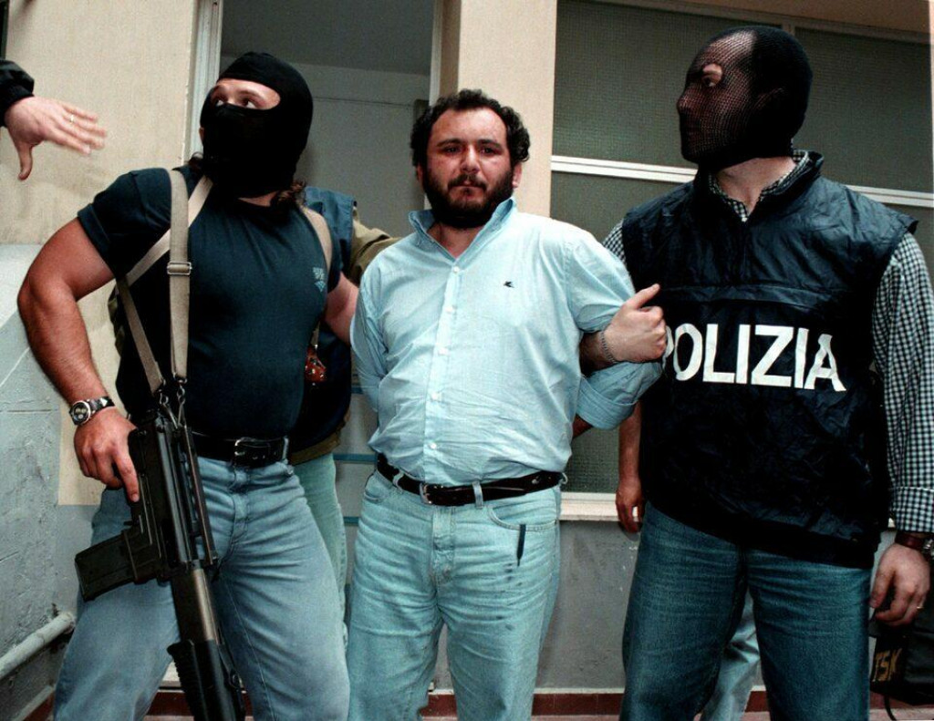 Polícia sprevádza popredného mafiánskeho utečenca Giovaniho Bruscu, keď odchádza z policajného riaditeľstva v Palerme, aby bol prevezený do väznice s maximálnym stupňom stráženia. (23. mája 1992). FOTO: Reuters