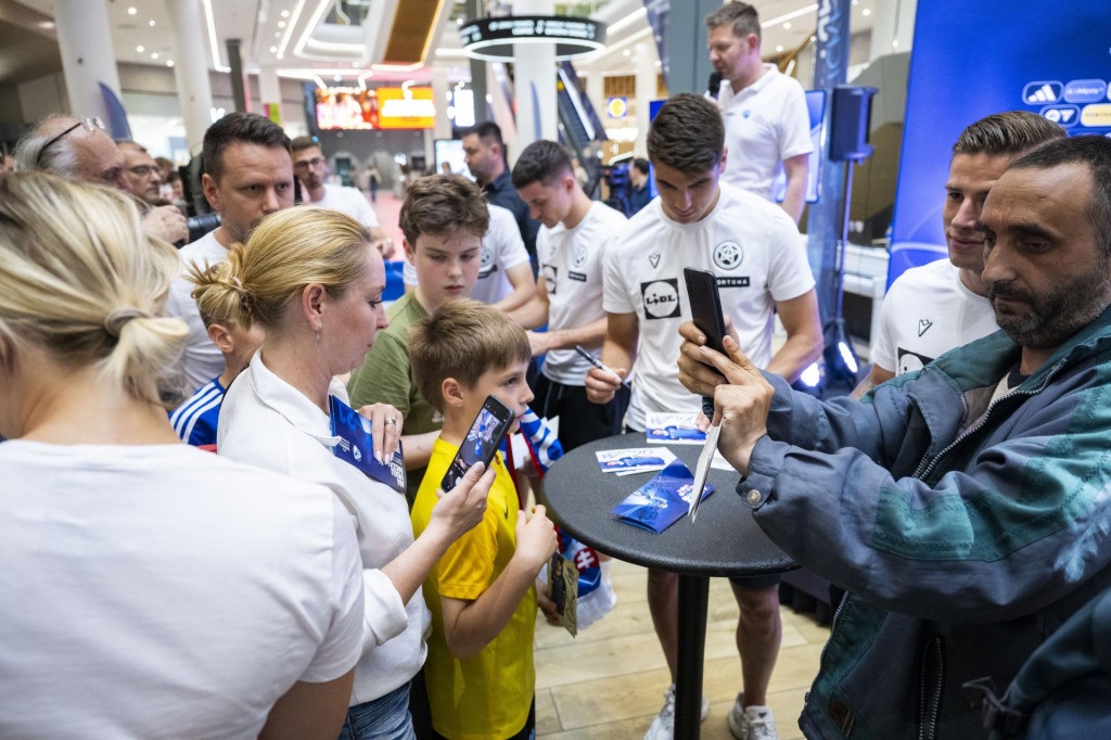 Slovenskí futbaloví reprezentanti do 21 rokov zľava Adrián Kaprálik, Adam Obert a Tomáš Suslov podpisujú karty fanúšikom pred domácimi Majstrovstvami Európy hráčov do 21 rokov. FOTO: TASR/Jakub Kotian