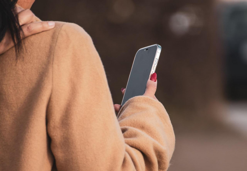 Žena, ktorá má v ruke smartphone. Na zábere je otočená chrbtom. FOTO: Pixabay