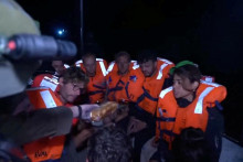 Izraelský vojak podáva jedlo ľuďom na palube jachty „Madleen“ plaviacej sa pod britskou vlajkou smerujúcej do Gazy po tom, čo izraelské sily vstúpili na palubu lode. FOTO: Reuters/Izraelské ministerstvo zahraničných vecí