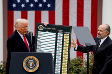 Americký prezident Donald Trump drží graf o clách vedľa amerického ministra obchodu Howarda Lutnicka. FOTO: Reuters