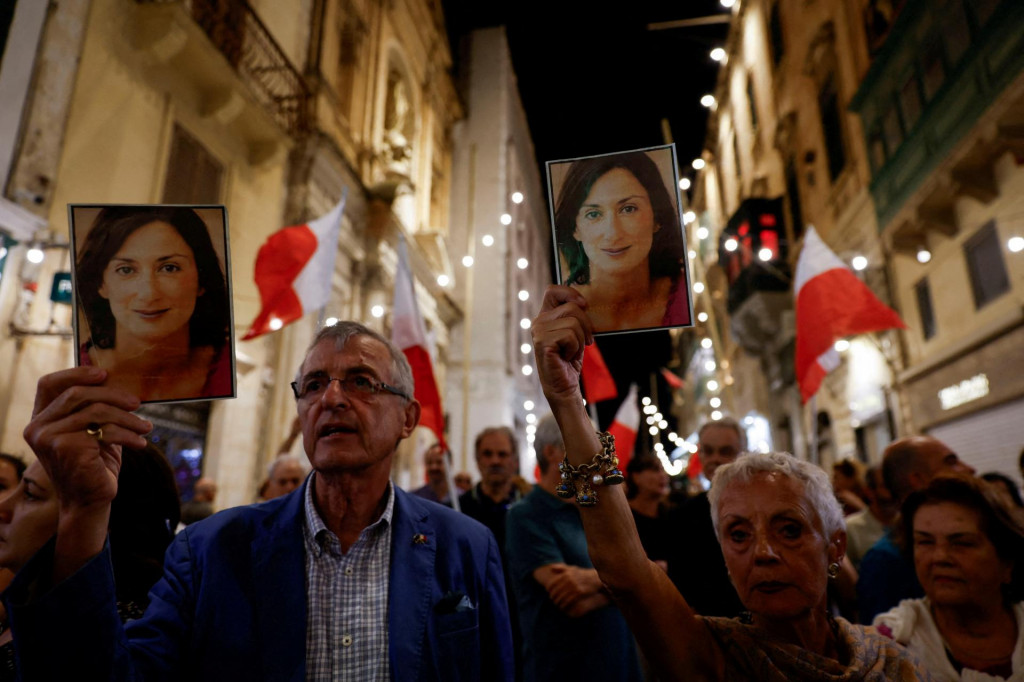 Ľudia držia fotografie zosnulej novinárky Daphne Caruanovej Galizie, ktorá bojovala proti korupcii, počas protestného pochodu pri príležitosti šiesteho výročia jej atentátu vo Vallette na Malte 16. októbra 2023. FOTO: REUTERS