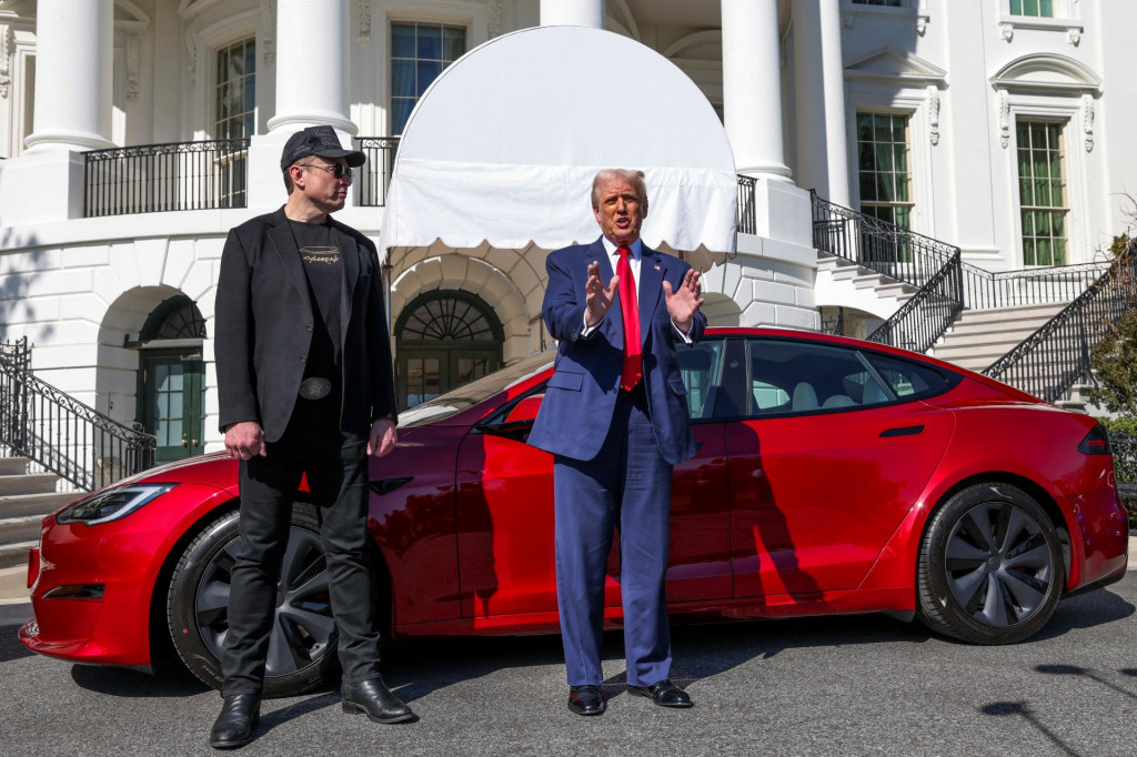 Americký prezident Donald Trump sa rozpráva s médiami vedľa generálneho riaditeľa spoločnosti Tesla Elona Muska, v pozadí je auto Tesla. FOTO: Reuters