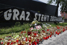 Kvety, sviečkynn a transparent s nápisom „Graz stojí spolu“. FOTO: Reuters