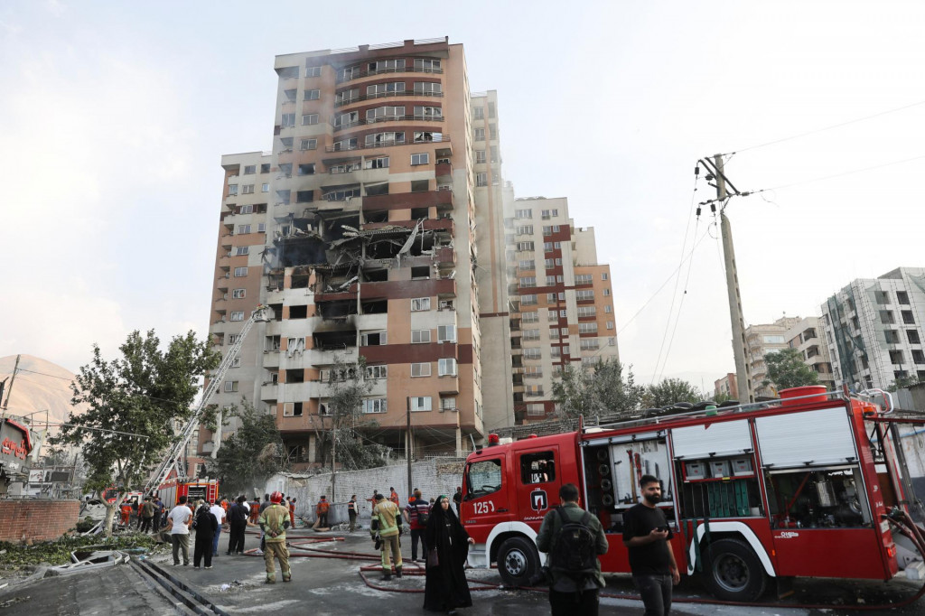 Hasiči pracujú na mieste poškodenej budovy po izraelských útokoch v Teheráne. FOTO: Reuters