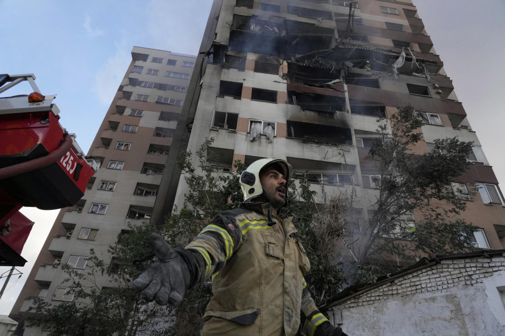Hasič zasahuje po útoku izraelskej armády na obytnú štvrť v iránskej metropole Teherán. FOTO: TASR/AP