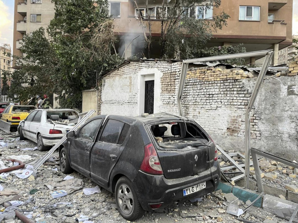 Vrak auta a materiálne škody po útoku izraelskej armády na obytnú štvrť v iránskej metropole Teherán. FOTO: TASR/AP