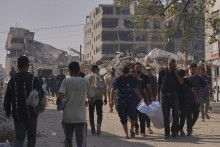 Palestínčania vynášajú telo osoby, ktorá zahynula v noci počas izraelských leteckých útokov v Pásme Gazy na ľudí čakajúcich na humanitárnu pomoc, neďaleko nemocnice Al-Šifa v meste Gaza. FOTO: TASR/AP