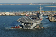 Remorkéry pomáhajú lietadlovej lodi triedy Nimitz USS Dwight D. Eisenhower (CVN 69) pri odťahovaní sa od móla v námornej základni Norfolk vo Virgínii. FOTO: REUTERS