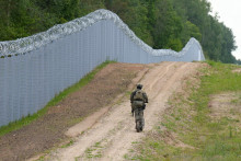 Príslušník lotyšskej špeciálnej jednotky pohraničnej stráže hliadkuje pozdĺž plota na lotyšsko-bieloruskej hranici neďaleko Robeznieki v Lotyšsku 8. augusta 2023. FOTO: REUTERS