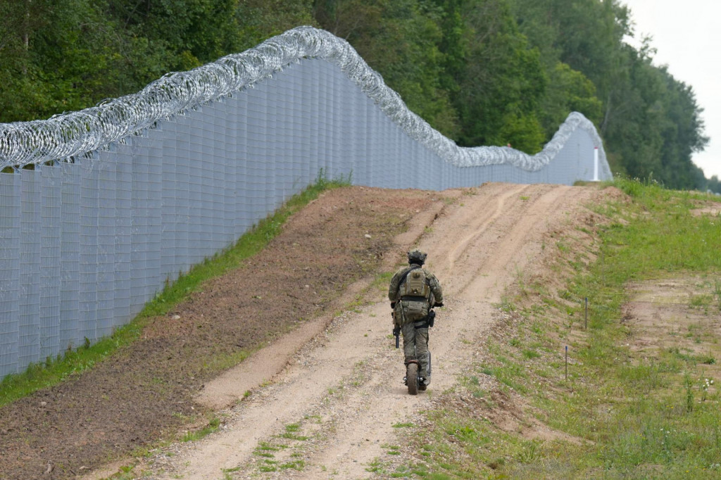 Príslušník lotyšskej špeciálnej jednotky pohraničnej stráže hliadkuje pozdĺž plota na lotyšsko-bieloruskej hranici neďaleko Robeznieki v Lotyšsku 8. augusta 2023. FOTO: REUTERS