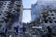 Hasiči zasahujú pred zničenou obytnou budovou po ruskom útoku v Kyjeve. FOTO: TASR/AP