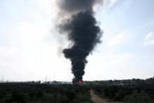 Dym stúpa z požiaru po iránskom raketovom útoku v izraelskom meste Herzlija. FOTO: Reuters