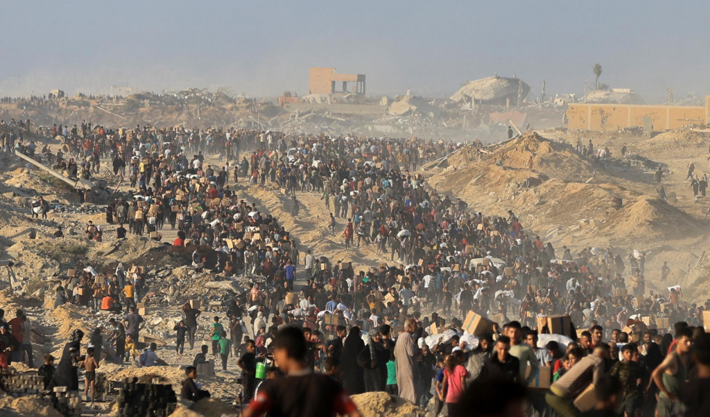 Palestínčania sa zhromažďujú, aby si prevzali pomoc v Beit Lahia v severnom Pásme Gazy. FOTO: Reuters