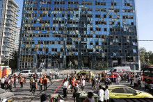 Záchranári pracujú na mieste útoku Iránu v izraleskom meste Ramat Gan. FOTO: Reuters