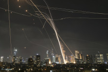 Projektil rakety udiera na budovy, zatiaľčo izraelský protivzdušný obranný systém páli na zachytenie rakiet počas iránskeho raketového útoku nad Tel Avivom. FOTO: TASR/AP