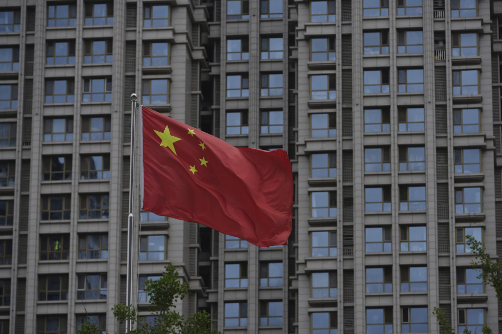 Čínska vlajka veje pri obytnej budove v Pekingu. FOTO: TASR/AP